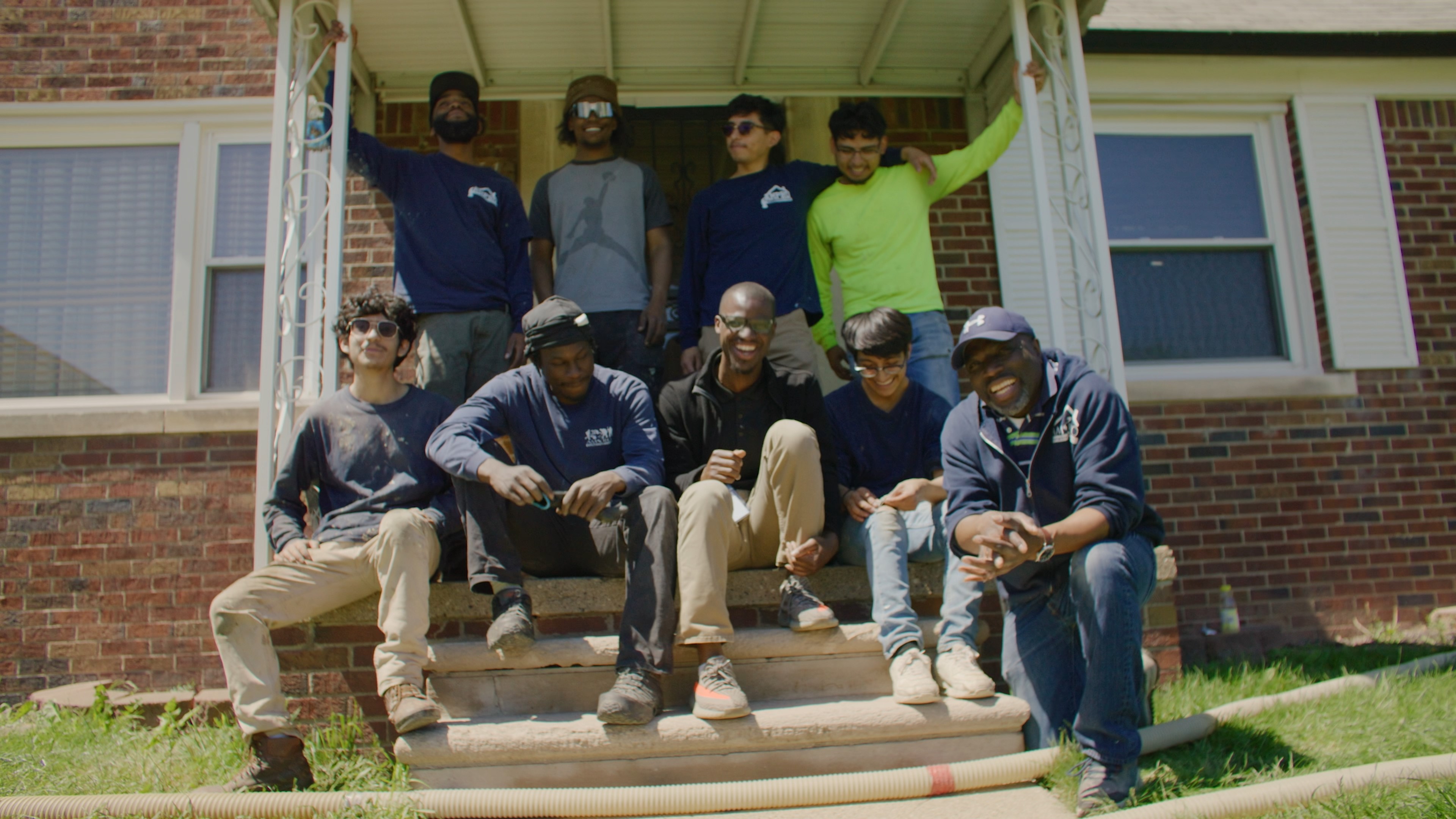 Alijah Thomas and his community gathered for a group photo on the porch of a house.