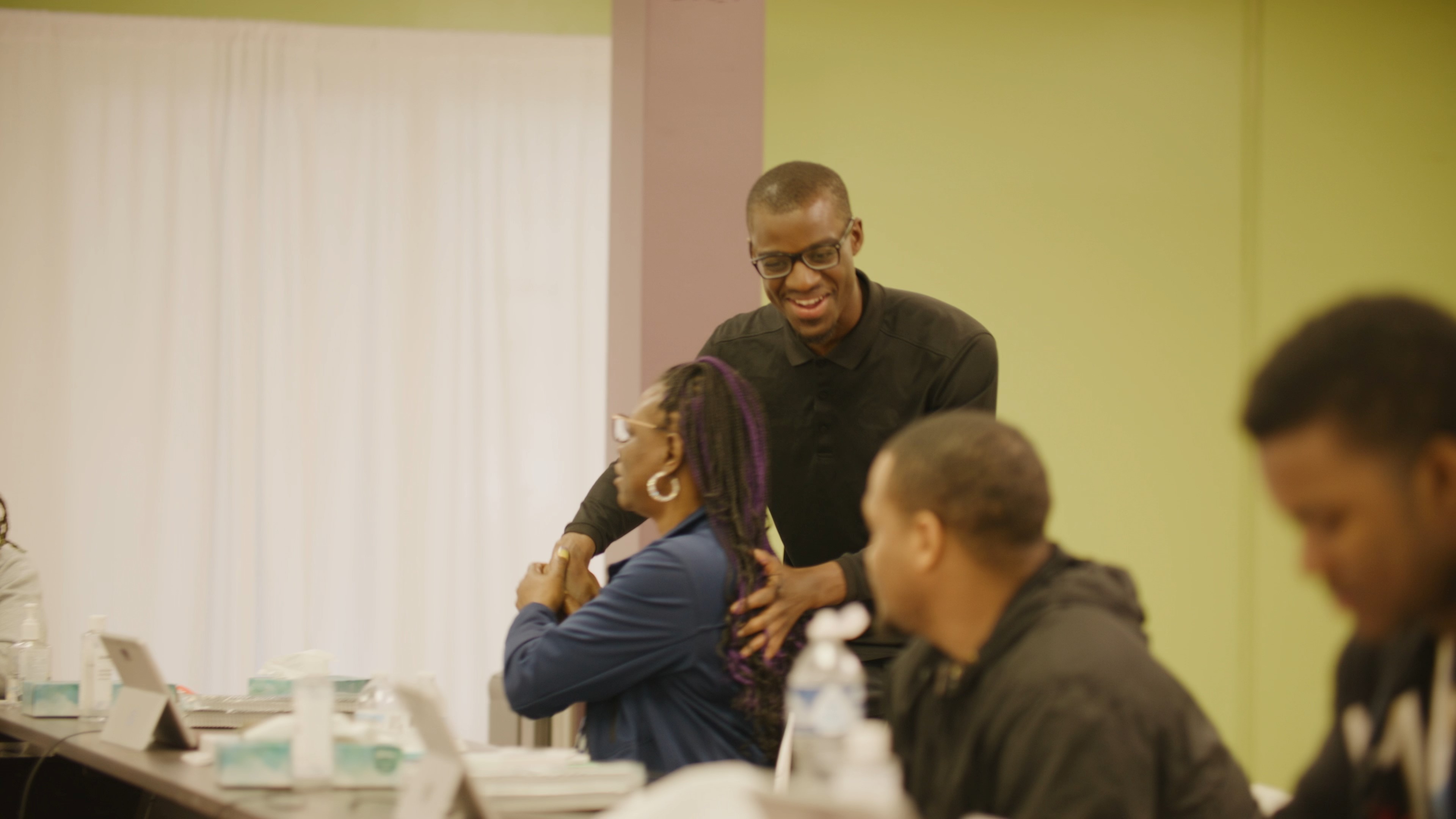 Alijah Thomas greeting people around a table.