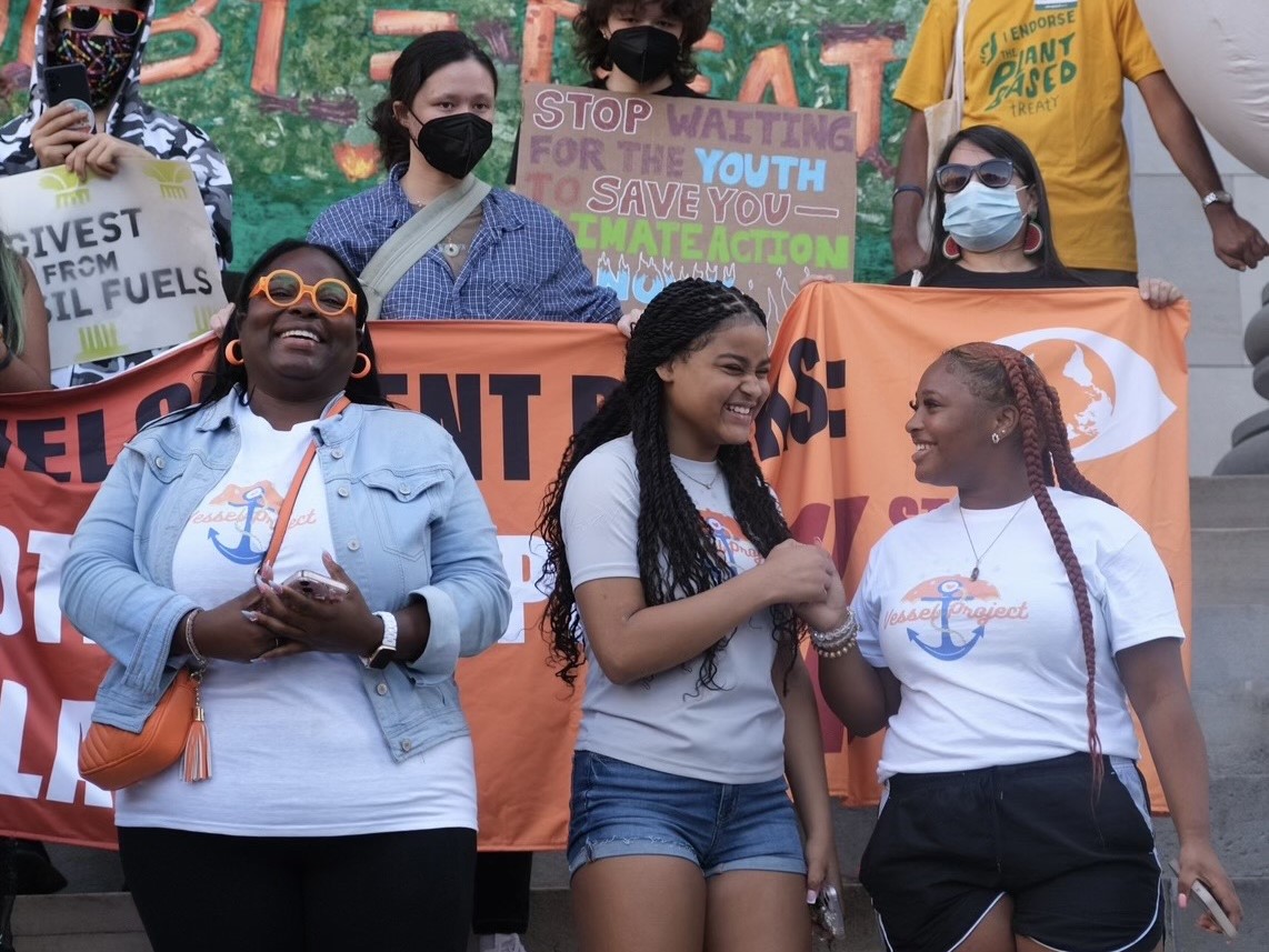 Roishetta Ozane and her community smiling at a climate protest.